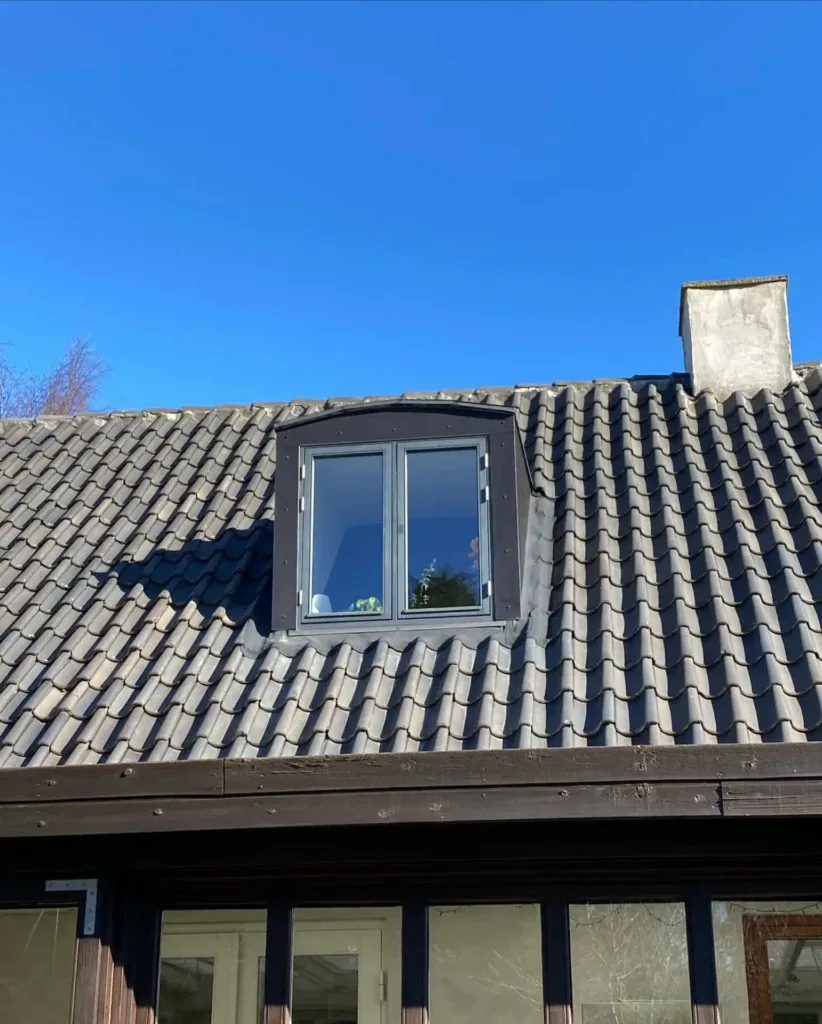 Nyrenoveret kviste på tag med sort ramme og tagsten.