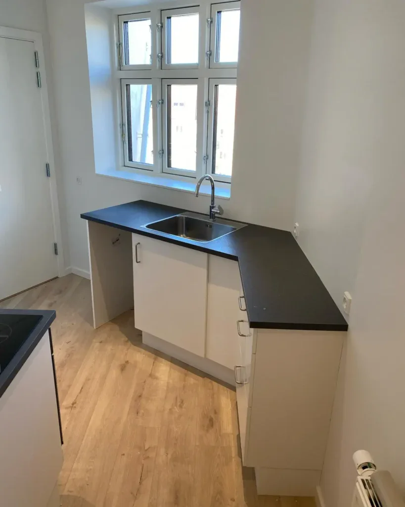 Effektivt køkken med nyt vaskerum og moderne skabsløsning til køkkenrenovering.