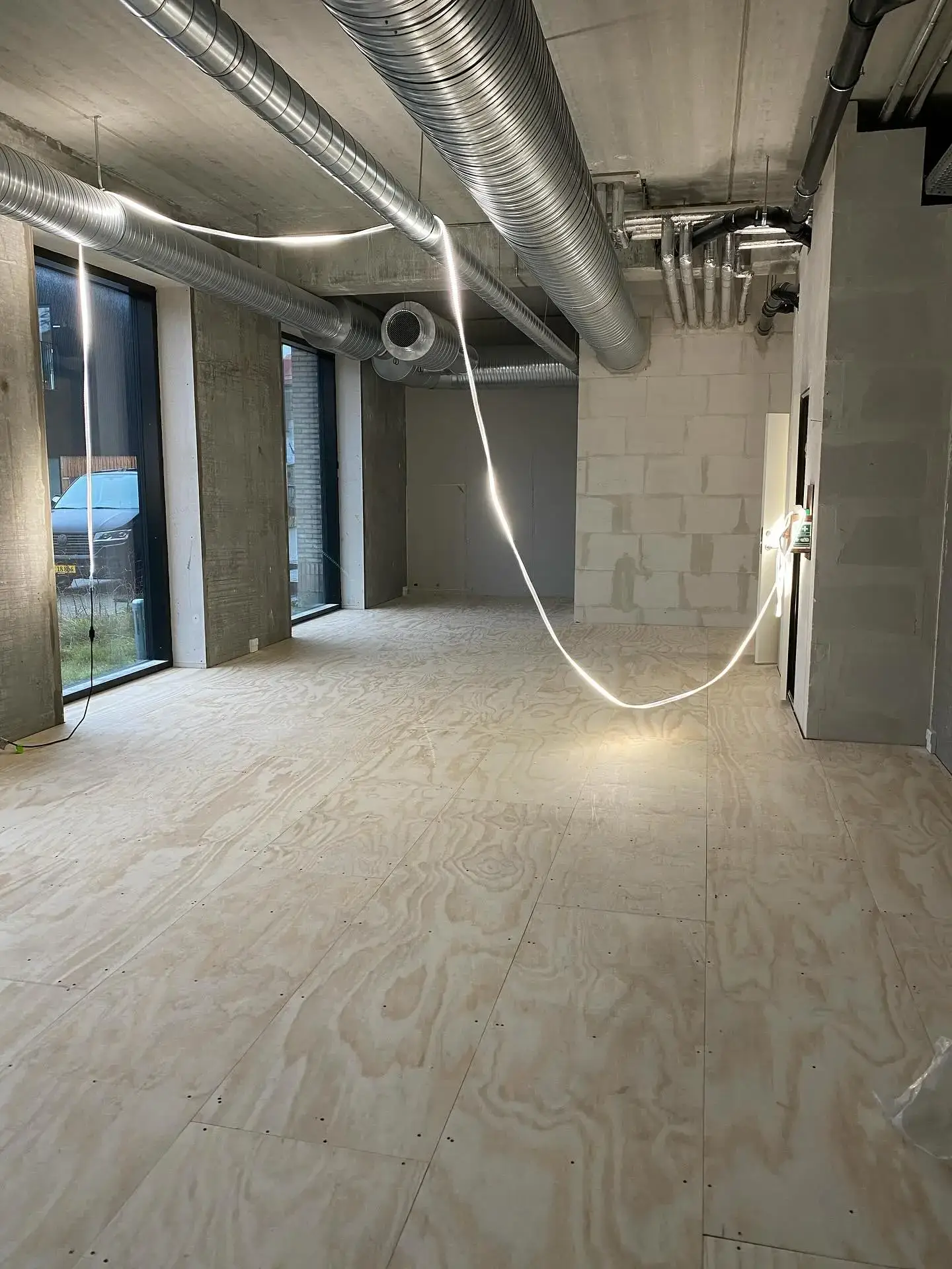 Udførelse af tømrerarbejde i et nyt byggeri med synlige ventilationsrør.