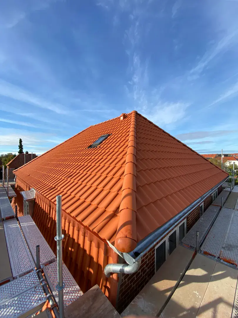 Nyt tag med røde teglsten på husets tag, professionelt udført af De Fries Tømrer & Snedker ApS.